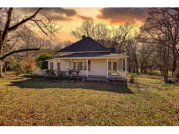 Charming two-story home with a covered porch and a well-maintained lawn at 4398 Highway 142, Newborn, GA 30056