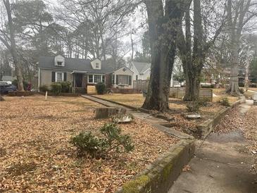 Charming single-Gathering home featuring a manicured lawn and mature trees on an overcast day at 1779 South Gordon Sw St, Atlanta, GA 30310