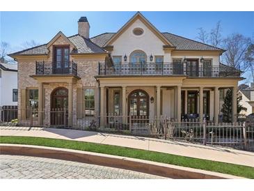 Elegant brick home with a charming front yard, second story terraces, and manicured landscaping at 440 Belada Blvd, Sandy Springs, GA 30342