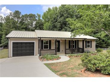 Charming single-story home with a metal roof, covered porch, and well-maintained landscaping at 612 Rich Davis Rd, Hiram, GA 30141