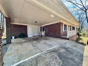 Spacious brick carport with covered parking and entry to the home's front door at 6198 Rocky Creek Dr, Douglasville, GA 30135