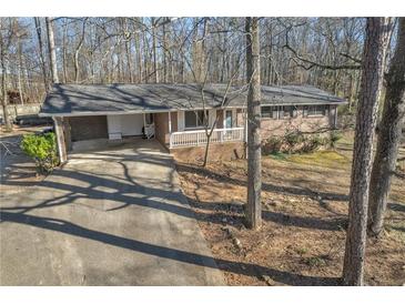 Charming single-story brick home featuring a covered front porch and attached carport with a concrete driveway at 6198 Rocky Creek Dr, Douglasville, GA 30135