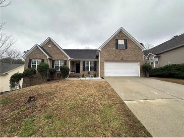 Charming brick home features an attached two-car garage and manicured front yard at 903 Creek Bottom Rd, Loganville, GA 30052