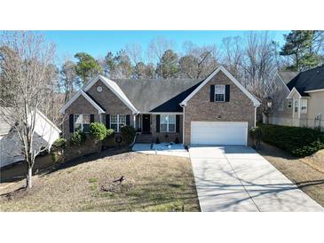 Charming single-Gathering home boasts a well-manicured lawn, a two-car garage, and classic brick facade at 903 Creek Bottom Rd, Loganville, GA 30052