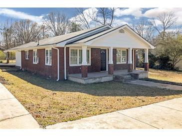 Charming brick home featuring a covered front porch with classic columns at 1729 Spring Ne St, Conyers, GA 30012