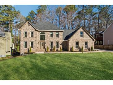 Brick two-story home with a well manicured lawn and mature trees at 5956 Henley Dr, Powder Springs, GA 30127