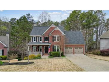 Charming two-story brick home with a covered front porch and attached two-car garage at 616 Redwood Ln, Canton, GA 30114
