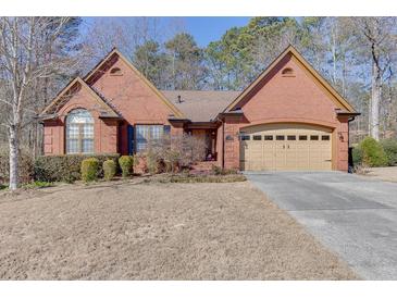 Charming brick home featuring manicured landscaping and an attached two-car garage at 1615 Creek Pointe Cir, Lawrenceville, GA 30043