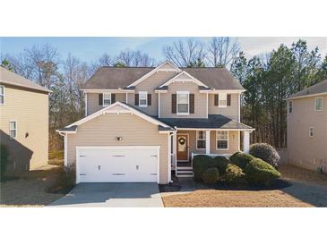 Charming two-story home featuring a welcoming front porch, attached garage, and well-maintained landscaping at 977 Forest Knoll Ct, Lithia Springs, GA 30122