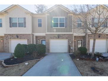 Charming townhome featuring a brick facade, an attached garage, and a well-manicured front yard at 3293 Pennington Dr, Stonecrest, GA 30038