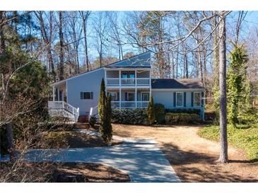 Charming two-story home with a double balcony and well-manicured landscaping at 3550 Beaver Cove Rd, Cumming, GA 30041