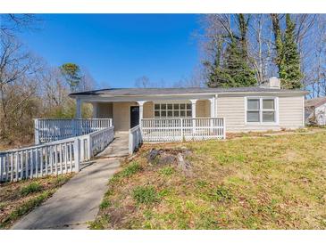 Charming single-story home featuring a covered porch, accessible ramp, and a well-maintained front yard at 940 Blair Bridge Rd, Austell, GA 30168
