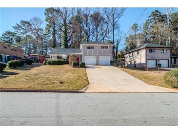 Charming split-level home with a well-manicured lawn and a long driveway leading to the two-car garage at 2236 Chestnut Hill Cir, Decatur, GA 30032