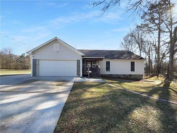 Charming home featuring a front-facing two-car garage, welcoming entrance, and well-maintained lawn at 1720 Winners Cir, Lawrenceville, GA 30043