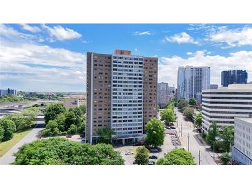 An exterior shot of the building shows a tall condo in a developed area at 215 Piedmont Ave # Apt 402, Atlanta, GA 30308