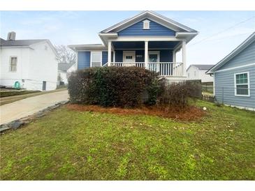 Charming blue home with a cozy front porch and well-maintained landscaping at 318 Kelly Se St, Atlanta, GA 30312