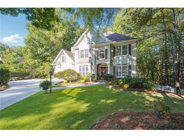 Charming two-story home with lush landscaping and a well-manicured lawn on a sunny day at 1678 Valor Ridge Nw Dr, Kennesaw, GA 30152