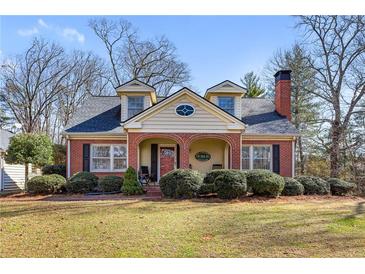 Charming brick home with dormers, a covered porch, and mature landscaping at 7452 Mount Vernon Rd, Lithia Springs, GA 30122