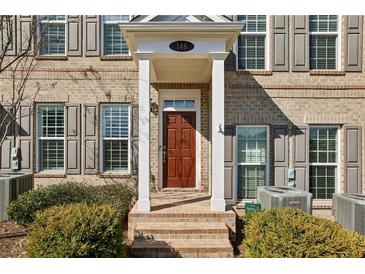 A welcoming brick home featuring a charming entrance with a covered porch and shuttered windows at 146 Rowan Ave, Alpharetta, GA 30009