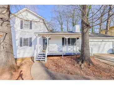 Charming two-story home featuring a covered front porch and a well-maintained yard with mature trees and a two-car garage at 3661 Silver Leaf Sw Ln, Marietta, GA 30008