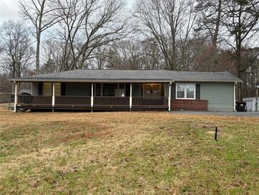 Charming single-story home featuring a covered porch and mature trees in a serene setting at 4749 Cox Se St, Acworth, GA 30101