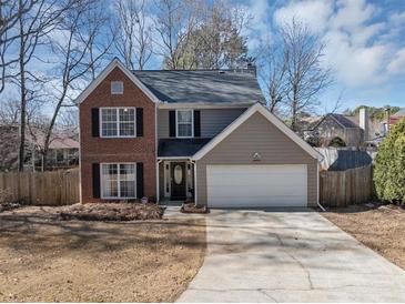 Charming two-story home featuring a brick facade, attached garage, and well-maintained landscaping at 1098 Berkley Se Dr, Smyrna, GA 30082