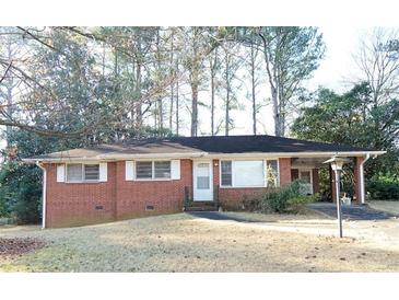 Charming one-story brick home with a well-maintained front yard and covered parking at 1879 Mural Cir, Morrow, GA 30260