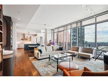 Spacious living room with hardwood floors, city views, and modern furnishings at 1065 Peachtree Ne St # 3005, Atlanta, GA 30309