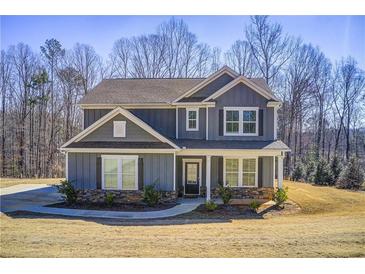 Charming two-story home features stone accents, a covered front porch, and professionally landscaped yard at 50 Crabapple Ridge Dr, Oxford, GA 30054