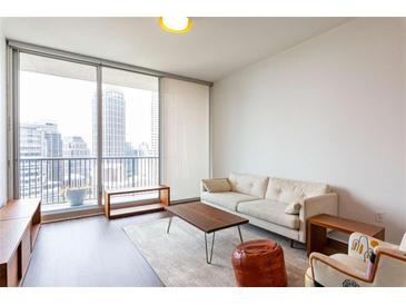 Bright living room with a comfortable sofa and a large window offering a stunning city view at 1080 Peachtree St # 2116, Atlanta, GA 30309