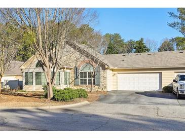 Charming single-story home with stone accents, a two-car garage, and a well-maintained lawn at 302 Gladstone Dr, Mcdonough, GA 30253