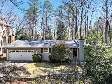 Charming home with a two-car garage and beautifully landscaped front yard and a brick chimney at 6275 Hunting Creek Rd, Atlanta, GA 30328