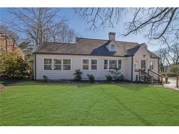 Charming home featuring a lush green lawn and neatly manicured landscaping at 1630 Sylvan Sw Rd, Atlanta, GA 30310