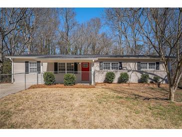 Charming single-story home featuring a well-maintained lawn and a vibrant red front door at 542 Oak Hills Sw Rd, Mableton, GA 30126