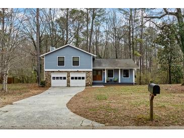 Charming blue two-story home featuring a stone-accented garage and inviting front porch at 9635 Loblolly Ln, Roswell, GA 30075