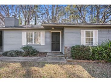 Charming home exterior features a black front door, complemented by white window shutters at 3759 Rosemary Se Ln, Conyers, GA 30013