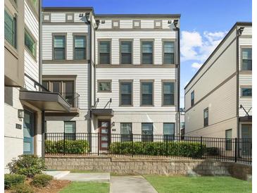 A charming three-story townhome featuring a well-kept lawn and a classic exterior design at 2028 Holtz Ln, Atlanta, GA 30318