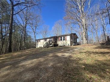 A charming single-story home nestled among mature trees on a sunny, grassy hill at 2540 Marsha Cir, Cumming, GA 30041