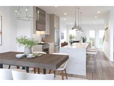 Well-lit kitchen featuring stainless steel appliances, a large island with seating, and an adjacent dining area at 201 New St # 2305-1, Decatur, GA 30030