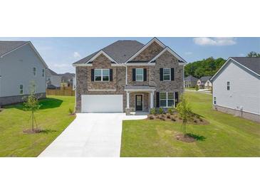 Beautiful two-story home with brick and siding exterior and well-maintained lawn at 1059 Blue Juniper Cir, Loganville, GA 30052