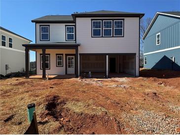 New two-story home featuring light siding, black trim, a covered patio, and an unfinished yard at 2108 Boxwood Circle Se, Conyers, GA 30094