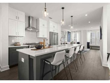 Modern kitchen featuring white cabinets, stainless steel appliances, and a large island with seating at 201 New St # 1102-8, Decatur, GA 30030