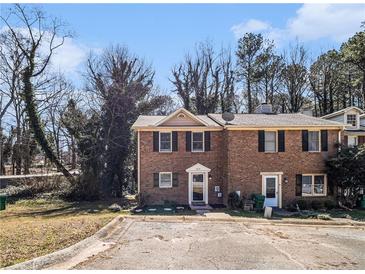 Charming brick townhome with a well-maintained lawn and mature trees at 5293 Oakridge Dr, Stone Mountain, GA 30083