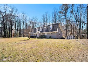 Charming gray home featuring dormer windows, a well-kept lawn, and mature trees on a sunny day at 487 Glendale Ct, Stone Mountain, GA 30087