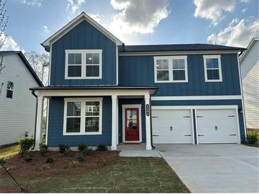 Two-story blue home featuring a red door, white trim, two-car garage and well-maintained lawn at , Conyers, GA 30094