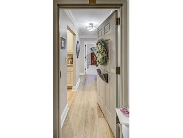 Inviting entryway featuring light wood floors, neutral walls, and a charming wreath on the unit door at 300 Johnson Ferry Ne Rd # A712, Atlanta, GA 30328