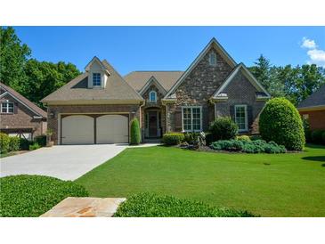 Charming brick and stone home with manicured lawn, two-car garage, and inviting curb appeal at 4880 Cecilia Sq, Cumming, GA 30040