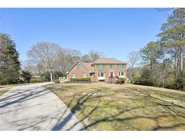 Charming two-story brick home with a landscaped front yard and driveway at 4805 Mystere Sw Ln, Lilburn, GA 30047