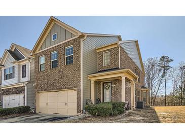 Two-story brick home featuring an attached garage, classic design elements, and a well-maintained front yard at 3362 Brockenhurst Dr, Buford, GA 30519