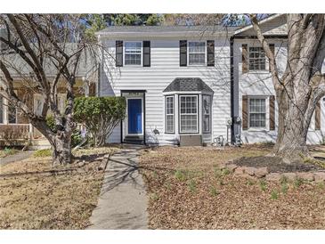 Charming two-story townhouse featuring a blue front door and a manicured front yard at 5043 Bell Dr, Smyrna, GA 30080
